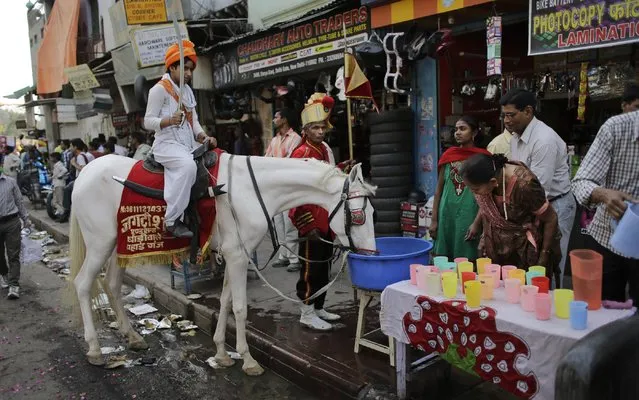 A horse carrying a Hindu girl drinks water  during a religious procession on Ram Navami festival in New Delhi, India, Saturday, March 28, 2015. Ram Navami marks the birth of Hindu God Rama. (Photo by Altaf Qadri/AP Photo)