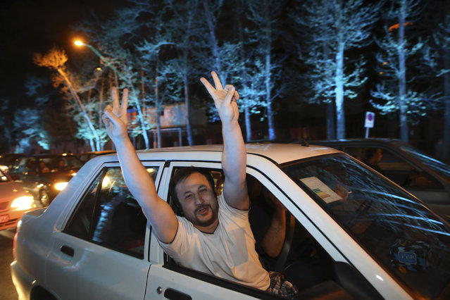 An Iranian man flashes the victory sign from his car while celebrating on a street in northern Tehran, Iran, Thursday, April 2, 2015, after Iran's nuclear agreement with world powers in Lausanne, Switzerland. (Photo by Vahid Salemi/AP Photo)