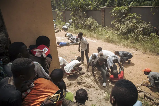 Protesters flee under FARDC military gunfire outside the offices of the electoral commission in Beni during a demonstration against the postponement of elections in Beni territory and the city of Butembo on December 27, 2018. (Photo by Alexis Huguet/AFP Photo)