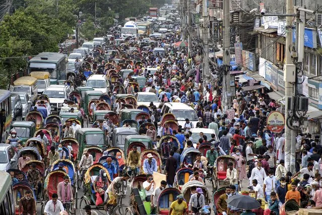People crowd a market area ahead of Eid-al Adha in Dhaka, Bangladesh, Friday, July 16, 2021. Millions of Bangladeshis are shopping and traveling during a controversial eight-day pause in the country’s strict coronavirus lockdown that the government is allowing for the Islamic festival Eid-al Adha. (Photo by Mahmud Hossain Opu/AP Photo)