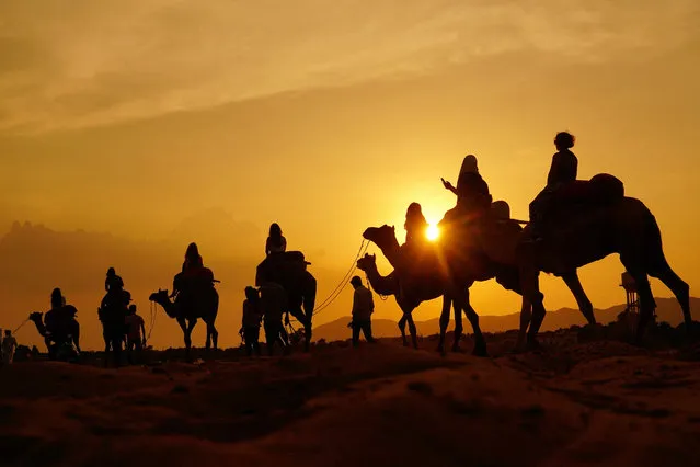 Tourists enjoy a camel safari at a desert in Pushkar on September 10, 2023. (Photo by Himanshu Sharma/AFP Photo)