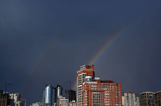 This photograph shows a rainbow above Ukrainian capital of Kyiv after raining on June 28, 2023. (Photo by Sergei Supinsky/AFP Photo)
