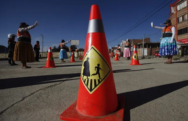 This November 28, 2013 photo shows a traffic cone adorned with a silhouette of a “cholita”, a child and a crosswalk, at a practice session for Aymara women training to direct traffic in El Alto, Bolivia. (Photo by Juan Karita/AP Photo)