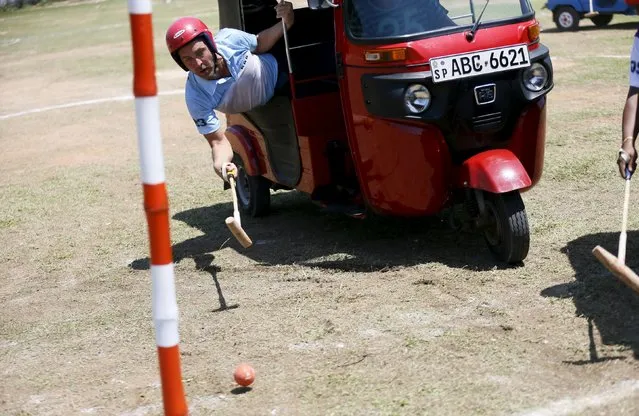 A competitor hits the ball to get a goal during a “Tuk Tuk” (Three-Wheeled) Polo game in Galle, Sri Lanka on February 21, 2016. (Photo by Dinuka Liyanawatte/Reuters)