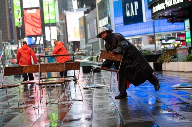 Workers remove chairs in Times Square as Tropical Storm Henri approaches, in New York on August 22, 2021. Tropical Storm Henri was on course to make landfall on the US east coast Sunday, with millions in New England and New York's Long Island preparing for flash flooding, violent winds and power outages. The US National Hurricane Center said in its 7:00 am (1200 GMT) advisory that Henri 50 miles (80 kilometers) southeast of Montauk Point in New York state. (Photo by Kena Betancur/AFP Photo)