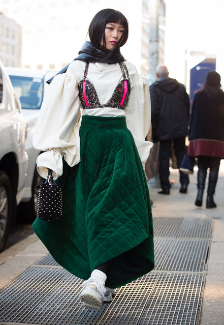 A guest walks outside of the Son Jung Wang show during New York Fashion Week wearing a black scarf, white shirt, green dress and white shoes on February 9, 2019 in New York City. (Photo by Donell Woodson/Getty Images)