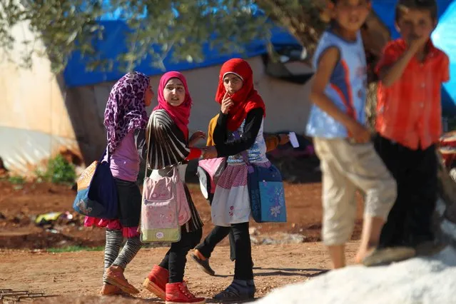Internally displaced Syrian girls carry school bags inside Safsafa camp, northern Idlib countryside, Syria March 1, 2016. (Photo by Ammar Abdullah/Reuters)