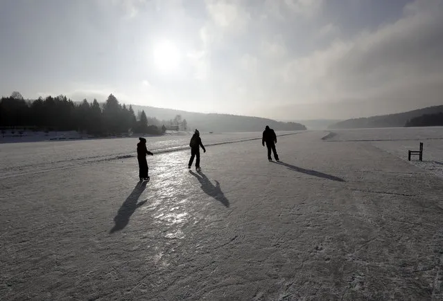 People enjoy a ride on a maintained icy track on the vast frozen surface of the Lipno dam near the village of Frymburk, Czech Republic, Friday, February 10, 2017. This year's unusually cold winter has turned a Czech lake resort into a skating heaven. With the ice thick well over the necessary 17 centimeters (6.7 inches) and a long wave of icy condition made it possible to skate on the largest Czech lake for the record three straight weeks. (Photo by Petr David Josek/AP Photo)
