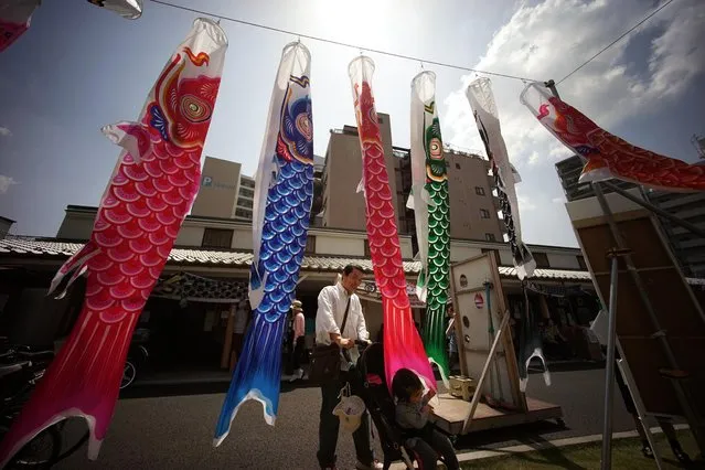 Carp streamers are hoisted in Tokyo, Saturday, May 2, 2015. The colorful streamers were hung to mark Children's Day on May 5, wishing children's healthy growth like carp that can swim up a waterfall. (Photo by Eugene Hoshiko/AP Photo)