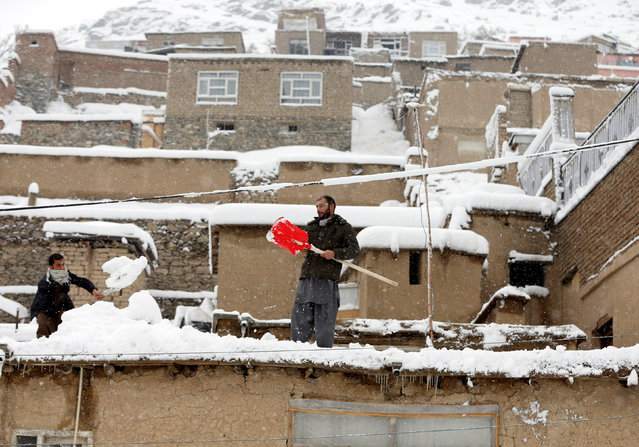 Afghan youth shovel snow from the roof of houses in Kabul, Afghanistan February 5, 2017. (Photo by Omar Sobhani/Reuters)