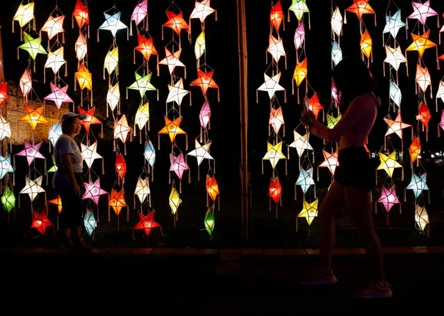 People take photos during the Loy Krathong festival which is held as a symbolic apology to the goddess of the river in Chiang Mai, Thailand, November 19, 2021. (Photo by Soe Zeya Tun/Reuters)