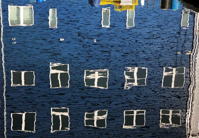 Windows take on different shapes as they reflect upon the water along a wharf in Portland, Maine, U.S., December 24, 2018. (Photo by Kevin Lamarque/Reuters)