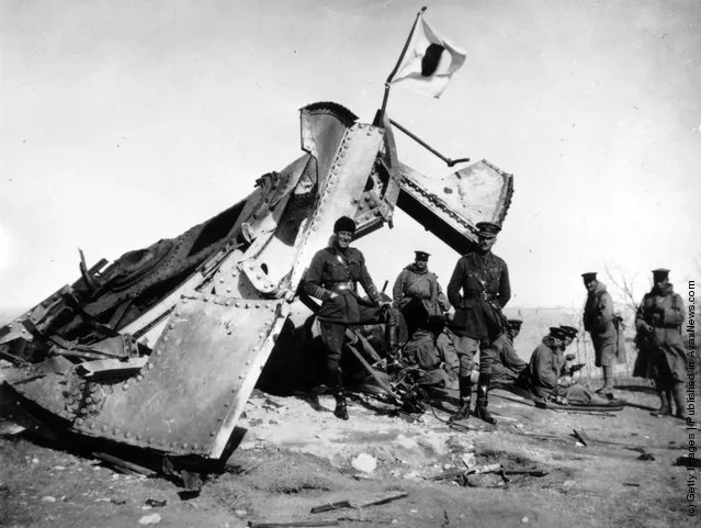 1914: British and Japanese officers stand by a Japanese flag flying over a wrecked German gun after the siege of Tsingtao