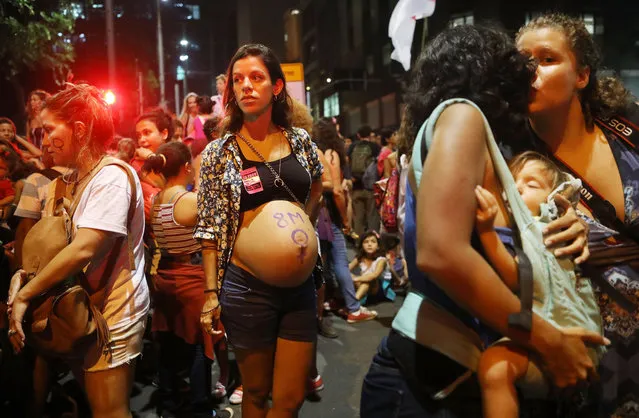 A pregnant woman stands (C) as a woman carries a young child on International Women's Day on March 8, 2017 in Rio de Janeiro, Brazil. Protestors rallied across the country for increased rights and protections for women. (Photo by Mario Tama/Getty Images)
