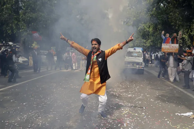 Bharatiya Janata Party (BJP) supporter celebrates as their party leads in state elections in Uttarakhand and Utter Pradesh states in New Delhi, India, Saturday, March 11, 2017. India's governing Hindu nationalist party is heading for major victories in key state legislature elections that are seen as a referendum on Prime Minister Narendra Modi's nearly 3-year-old rule. (Photo by Tsering Topgyal/AP Photo)
