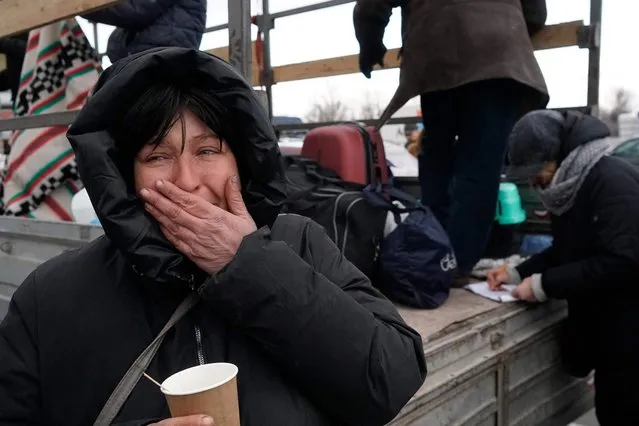Evacuees from Mariupol are seen upon arrival at the car park of a shopping centre on the outskirts of the city of Zaporizhzhia, which is now a registration centre for displaced people, on March 16, 2022. Some 20,000 residents have been allowed to leave Mariupol through a humanitarian corridor agreed with Russian forces. But exhausted, shivering evacuees speak of harrowing escape journeys and rotting corpses littering the streets. Mariupol is facing a humanitarian catastrophe according to aid agencies, since heavy bombardment has left some 400,000 inhabitants with no running water or heating and food running short. More than 2,100 residents have been killed in Mariupol since the Russian invasion, according to city authorities. (Photo by Emre Caylak/AFP Photo)