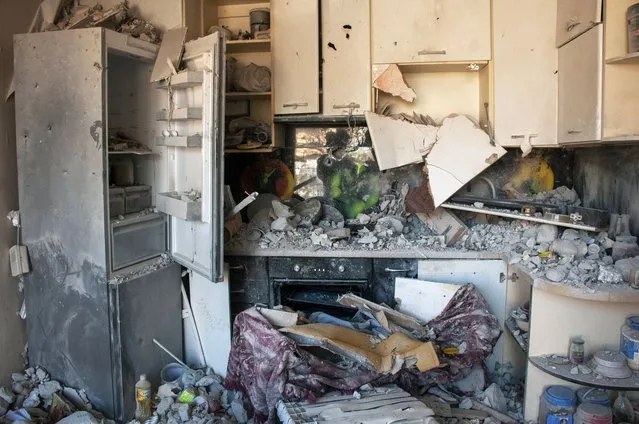 Utensils are seen inside a damaged kitchen at an apartments building hit by shelling in Kharkiv, Ukraine, Sunday, March 20, 2022. (Photo by Andrew Marienko/AP Photo)