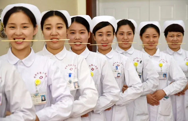 Nurses practice smiling with chopsticks in their mouths at a hospital in Handan, Hebei province, China, May 8, 2017. (Photo by Reuters/Stringer)
