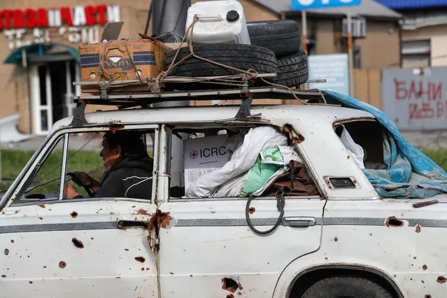 A man transports his belongings in a car in the course of Ukraine-Russia conflict in the southern port city of Mariupol, Ukraine on May 3, 2022. (Photo by Alexander Ermochenko/Reuters)