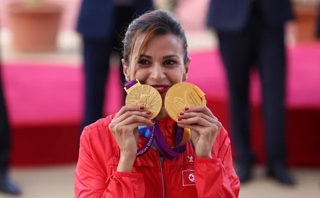 Habiba Ghribi of Tunisia poses with her gold medals for the Olympic 2012 and World 2011 3,000-metre steeplechase in Tunis, Tunisia, June 4, 2016. Ghribi received the medals on Saturday after the medals were stripped from Russia's Yuliya Zaripova due to doping. (Photo by Zoubeir Souissi/Reuters)
