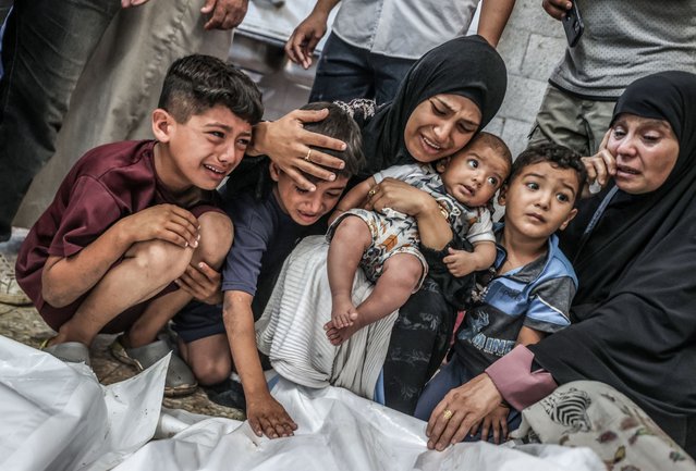 Relatives of Palestinians, who killed in Israeli attack, mourn after their bodies were brought to the al-Aqsa Martyrs Hospital for burial in Deir al-Balah, Gaza on August 18, 2024. (Photo by Ali Jadallah/Anadolu via Getty Images)