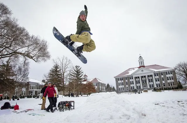 A university student snowboards off a ramp on the Quad in Harrisonburg, Virginia, US on January 15, 2022. (Photo by Daniel Lin/AP Photo)