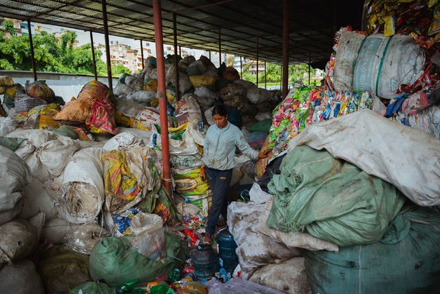 A worker pauses for a moment from sorting through recyclable goods at the Avni recycling plant on August 18, 2024 in Kathmandu, Nepal. Avni Ventures is a green social business based in Kathmandu that is pioneering the circular economy in Nepal through PET collection and recycling, green technology R&D, sustainability education, and consultancy services. As the largest responsible plastic waste collection and recycling network in Nepal, Avni has created a formal supply chain, supported waste entrepreneurs, and partnered with local governments to reduce CO2 emissions and eliminate child labor in the waste sector. The company is also the official recycling partner of the Mountain Clean Up Campaign, led and coordinated by the Nepali Army, in charge of sorting and processing the recyclable waste collected from Mount Everest, the world's tallest mountain. (Photo by Mailee Osten-Tan/Getty Images)