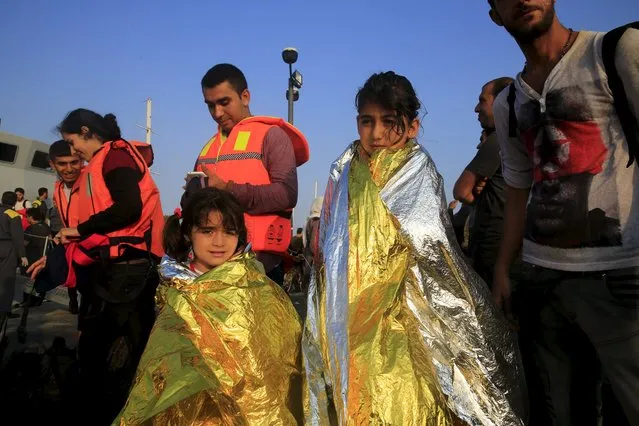 Syrian refugees from Kobani are covered by thermal blankets in the port of Kos following a resque mission off the Greek island of Kos August 10, 2015. (Photo by Yannis Behrakis/Reuters)