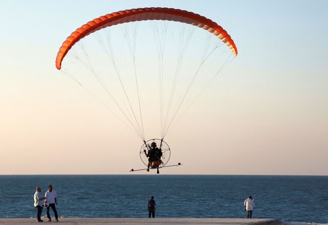 An Egyptian performance flies on a paramotor during his show at the beach along the Mediterranean Sea of the Walk of North Square during New Al Alamein Festival 2nd Edition 2024, in New al-Alamein City, Egypt, on August 8, 2024. (Photo by Amr Abdallah/Reuters)