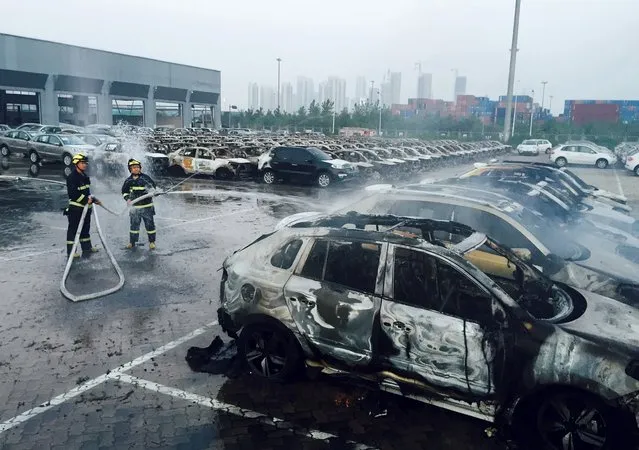 Firefighters work at a parking lot at the site of explosions at the Binhai new district in Tianjin August 13, 2015. Two massive explosions caused by flammable goods ripped through an industrial area in the northeast Chinese port city of Tianjin late on Wednesday, killing 17 people and injuring around 400, official Chinese media reported. (Photo by Reuters/Stringer)