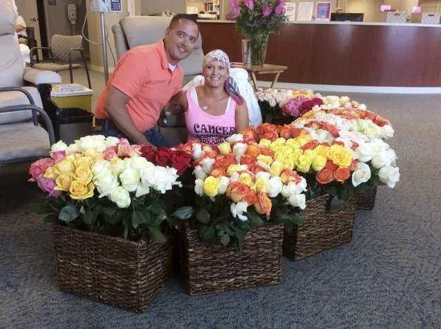 This June 23, 2016 photo provided by Brad Bousquet shows Bousquet with his wife, Alissa, and the 500 roses he presented to her at the Methodist Estabrook Cancer Center in Omaha, Neb., to celebrate her last chemotherapy treatment. Brad writes that he secretly texted wife Alissa's friends and family to help with the effort. The roses sold for $10 each with the proceeds going to the Susan G. Komen Foundation for breast cancer research. (Photo by Brad Bousquet via AP Photo)