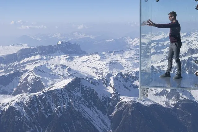 Visitors can test their nerve on the viewing area at the top of the Aiguille du Midi mountain in Chamonix, France on March 23, 2022. (Photo by Rick Findler/Story Picture Agency)