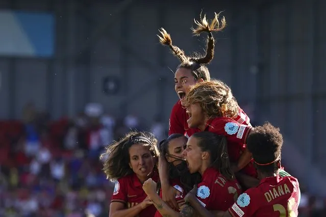 Portugal's Jessica Silva, covered by her teammates, celebrates after scoring his side's second goal during the Women Euro 2022 soccer match between Portugal and Switzerland at Leigh Sports Village in Wigan & Leigh, England, Saturday, July 9, 2022. (Photo by Dave Thompson/AP Photo)