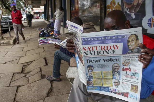 A man reads a newspaper whose front page shows the two leading presidential candidates Raila Odinga and William Ruto, on a street in downtown Nairobi, Kenya Saturday, August 6, 2022. Kenya is due to hold its general election on Tuesday, Aug. 9 as the East Africa's economic hub chooses a successor to President Uhuru Kenyatta. (Photo by AP Photo)