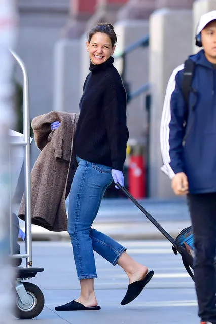 Katie Holmes and Suri Cruise appear to flee New York City during the ongoing Coronavirus crisis on March 27, 2020. The 41 year old actress seemed in good spirits as she pulled luggage to an SUV while wearing protective gloves, black sweater, jeans, and slippers. Suri handled their two dogs while a worker helped out by pushing a loaded luggage cart. (Photo byTheImageDirect.com)