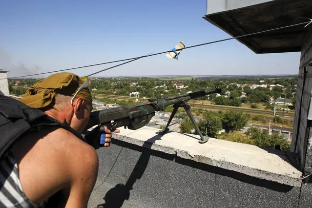 A Ukrainian serviceman checks his Soviet-made armor-piercing rifle at a position on the roof of a building outside Donetsk, August 15, 2014. The European Union said on Friday it would consider any unilateral military actions by Russia in Ukraine as “a blatant violation of international law”. (Photo by Valentyn Ogirenko/Reuters)