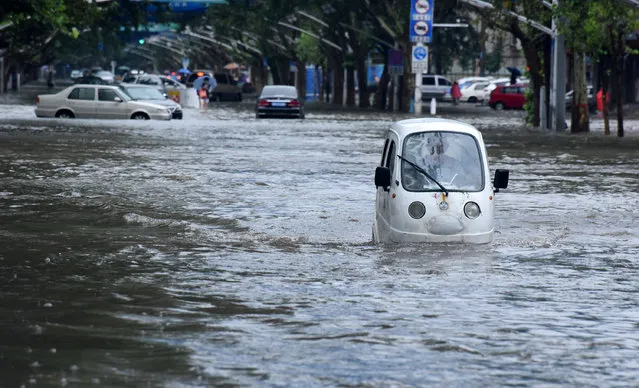A vehicle is seen passing a flooded street in Handan, Hebei Province, China, July 20, 2016. (Photo by Reuters/Stringer)