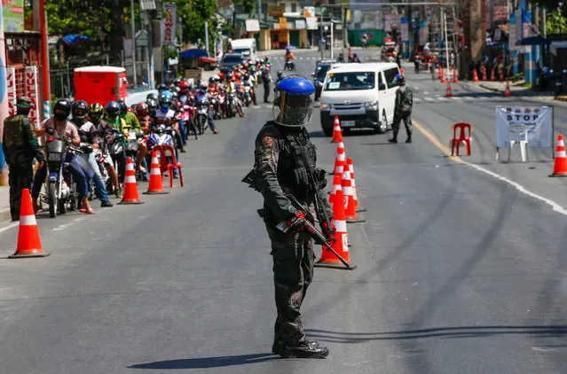 A police officer guards a checkpoint at the border between Rizal province and Marikina City, Metro Manila, Philippines 02 April 2020. In a late night broadcast on 01 April, Philippine President Rodrigo Duterte warned against intimidating and challenging the government, and ordered police and military to “shoot dead” troublemakers who will endanger the lives of security forces. (Photo by Rolex Dela Pena/EPA/EFE)