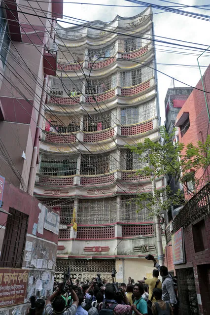 Bangladeshi journalists gather in front of the Taj Manzil, a five-story building that was raided by police in Dhaka, Bangladesh, Tuesday, July 26, 2016. (Photo by AP Photo)