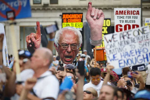 Supporters of former Democratic presidential candidate Bernie Sanders hold up posters at a “Black Men For Bernie” rally to gain support for third party candidates and protest the DNC during the 2016 Democratic National Convention on July 27, 2016 in Philadelphia, Pennsylvania. (Photo by Patrick T. Fallon/AFP Photo)