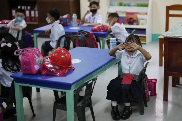 A girl cries during the opening of classes at the San Juan Elementary School in Pasig, Philippines on Monday, August 22, 2022. Millions of students wearing face masks streamed back to grade and high schools across the Philippines Monday in their first in-person classes after two years of coronavirus lockdowns that are feared to have worsened one of the world's most alarming illiteracy rates among children. (Photo by Aaron Favila/AP Photo)