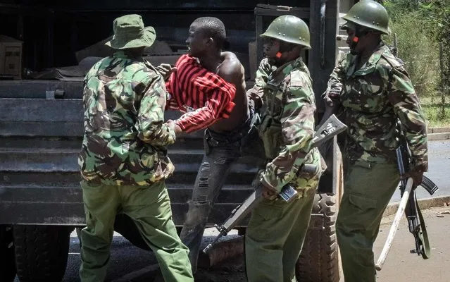 Kenya' s police officers clash with an opposition supporter taking part in a protest to call for the resignation of the Independent Electoral and Boundaries Commission (IEBC) officials over claims of bungling the August presidential vote, which was nullified by the Supreme Court, in Kisumu, on October 9, 2017 Opposition leader Raila Odinga, has called for protests this week, reiterated that he would not take part in a re- run of the presidential election on October 26, 2017 if his demands are not met, as Kenya' s Supreme Court last month overturned the August election of President Uhuru Kenyatta citing “irregularities” in the counting of results. (Photo by Brian Ongoro/AFP Photo)