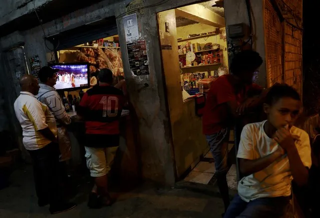 2016 Rio Olympics, Opening Ceremony, Maracana, Rio de Janeiro, Brazil on August 5, 2016. Residents of Mangueira favela watch the opening ceremony on TV. (Photo by Ricardo Moraes/Reuters)