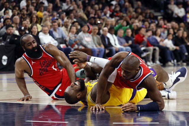 Los Angeles Lakers forward LeBron James, center, falls to the ground with Los Angeles Clippers Kris Dunn, right, and James Harden, left, during the second half of an NBA basketball game Tuesday, February 4, 2025, in Los Angeles. (Photo by Kevork Djansezian/AP Photo)