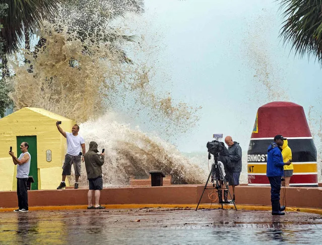 News crews, tourists and local residents take images as high waves from Hurricane Ian crash into the seawall at the Southernmost Point buoy, Tuesday, September 27, 2022, in Key West, Fla. Ian was forecast to strengthen even more over warm Gulf of Mexico waters, reaching top winds of 140 mph (225 kmh) as it approaches the Florida’s southwest coast. (Photo by Rob O'Neal/The Key West Citizen via AP Photo)