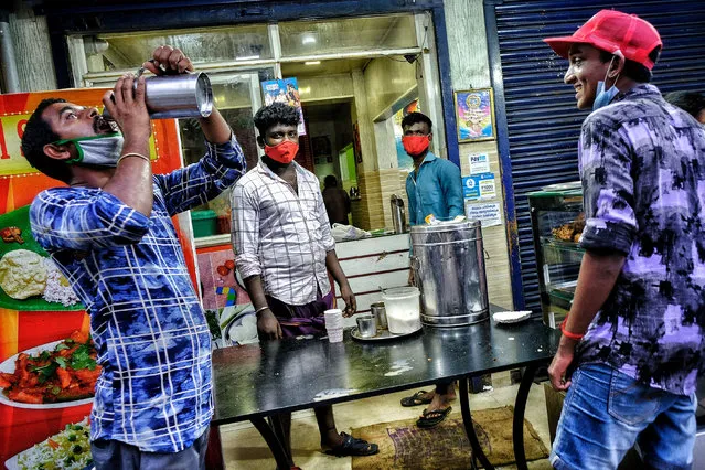 People with face masks take tea outside a restaurant during the lockdown in Kochi, India on May 25, 2020. At the beginning of the fourth phase of a nationwide lockdown in Kerala, several relaxations and new guidelines for the state are to be followed during this period of the prolonged lockdown. (Photo by Oscar Espinosa/SOPA Images/Rex Features/Shutterstock)