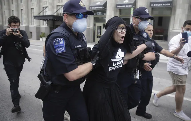 Tulsa Police officers arrest protester for trespassing after she entered the safety barricade of President Donald Trump's campaign rally Saturday June 20, 2020. (Photo by Mike Simons/Tulsa World via AP Photo)