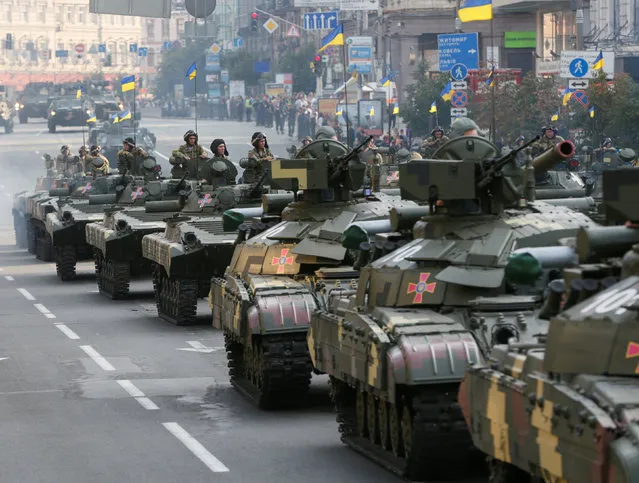 Ukrainian servicemen sit atop tanks and infantry fighting vehicles before a rehearsal for the Independence Day military parade in central Kiev, Ukraine, August 22, 2016. (Photo by Valentyn Ogirenko/Reuters)