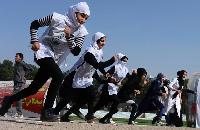 Afghan schoolgirls take part in a running race held for a peace initiative in Herat Province on November 11, 2016. (Photo by Aref Karimi/AFP Photo)