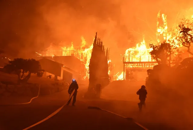 Firefighters work to put out a blaze burning homes early Tuesday, December 5, 2017, in Ventura, Calif. (Photo by Ryan Cullom/Ventura County Fire Department via AP Photo)